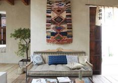 a living room filled with furniture and a rug hanging on the wall