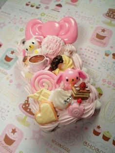 there is a pink cake with lots of candies and other things on it,