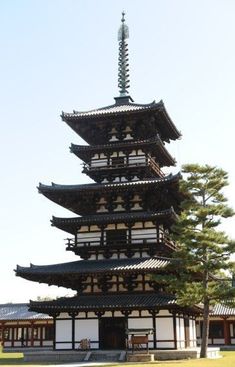 a tall building with many windows in the middle of it's roof and trees around it