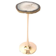 a white table with a gold base and an agate slice on it's top