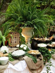 a table topped with lots of food and plants