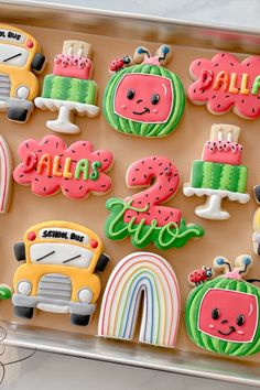 decorated cookies in the shape of school bus and watermelon are displayed on a tray