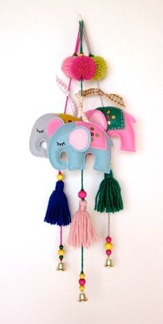 an elephant mask with tassels hanging from it's side on a wall