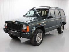 a green jeep is parked in a white room