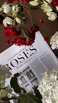 flowers are laying on the floor next to a newspaper with roses in front of it