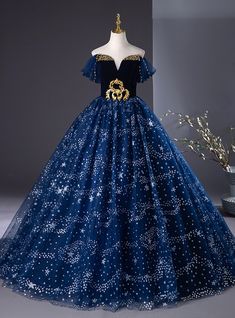 Every inch of this dress exudes elegance and fairy-tale allure! From the moment you slip into this stunning midnight blue gown, you'll feel like a princess stepping into a starry night. The golden embroidered detailing on the bodice creates a striking contrast against the deep, velvety fabric, making it both regal and radiant. The off-shoulder sleeves give a soft and ethereal feel, while the full tulle skirt, dotted with twinkling stars, ensures every movement is graceful and captivating. Perfect for a prom or any grand occasion, this dress brings a dreamy celestial charm to life, allowing you to shine under the spotlight with confidence and grace. Gold Princess Gown For Prom Season, Gold Princess Gown For Prom, Princess Style Gold Gown For Prom, Gold Princess Gown For Debutante Ball, Princess Style Gold Gown For Debutante Ball, Royal Blue Princess Dress For Wedding, Gold Princess Style Gown For Prom, Celestial Dress Gowns, Silver Homecoming Dresses