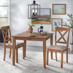 a dining room table with two chairs and a vase on the table next to it