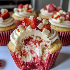 cupcakes with white frosting and strawberries on top