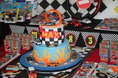 a birthday cake is decorated with cars and hot wheels