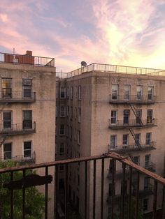 an apartment building with balconies on the top floor and balcony railings at sunset