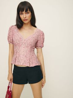 Up top. Shop the Minette Top from Reformation, a fitted top with a v-neckline, button front, short puffed sleeves, and lace detailing. Feminine Fitted V-neck Puff Sleeve Top, Feminine V-neck Tops With Button Closure, Feminine V-neck Top With Button Closure, Feminine Fitted V-neck Blouse, Fitted V-neck Puff Sleeve Top, Fitted V-neck Puff Sleeve Top For Daywear, Feminine V-neck Fitted Puff Sleeve Top, Feminine Fitted Buttoned Top, Feminine Fitted Tops With Buttons