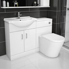 a white toilet sitting next to a sink in a bathroom