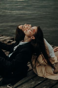 two women laying on the ground next to each other with their eyes closed and noses close together