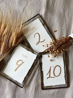 the table numbers are placed on top of each other with wheat stalks in front of them