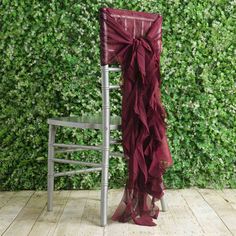 a chair with a red ruffled sash on it sitting in front of a green wall