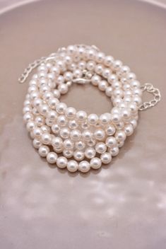 three strands of white pearls on a silver plate