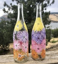 two glass vases with painted flowers on them