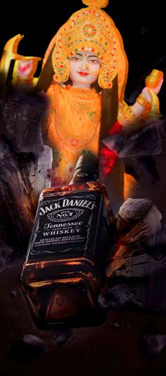 a bottle of jack daniels sitting in front of a statue