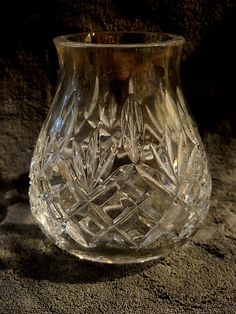 a clear glass vase sitting on top of a table next to a brown carpeted floor