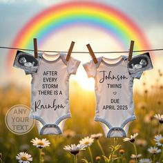 two baby onesuits hanging on a clothes line in front of a rainbow