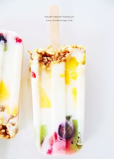 two popsicles with different toppings on them sitting next to each other in front of a white background