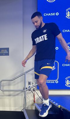 a man riding a skateboard on top of a metal hand rail in front of a blue wall