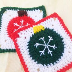 two crocheted coasters sitting on top of a white table covered in snowflakes