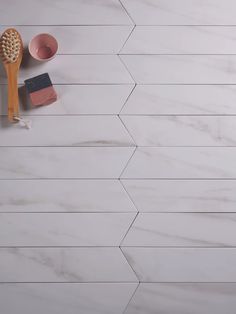 a bathroom counter with marble tiles and wooden utensils on it, along with other items