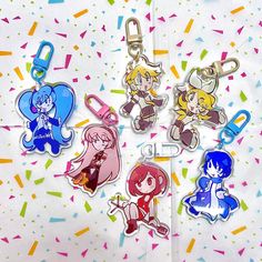 four cartoon keychains with different designs on them