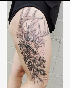 a woman's thigh with deer head and flowers on it