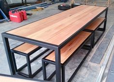 three benches sitting on top of each other in front of a metal frame and wood table