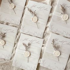 the wedding stationery is laid out on top of each other with buttons and flowers