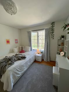 a bed room with a neatly made bed and a window