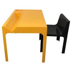 a small yellow table and black chair sitting next to each other