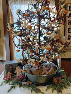 a small christmas tree in a metal bowl on a table next to other ornaments and decorations