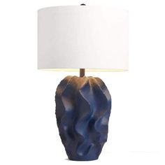 a blue ceramic lamp with a white shade