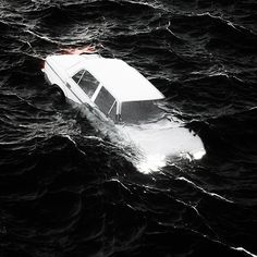 a small white boat floating on top of the ocean