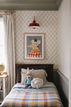 there is a bed in the room with two stuffed animals on it and a painting above