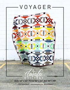 the cover of voyage magazine with an image of a quilted blanket in front of a white brick wall