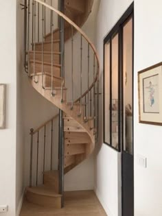 there is a spiral staircase in the house with wood treads and metal handrails