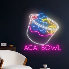 a neon sign that says acai bowl on the wall next to a white chair