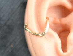 an ear is shown with a gold ring on it