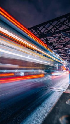 blurry photograph of city street at night with lights from cars passing by in the foreground