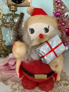 a stuffed santa clause holding a wrapped present