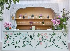 an elaborately decorated bar with flowers and vases on it