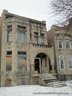 an old building with snow on the ground and stairs leading up to it's entrance