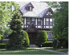 a large brown and white house surrounded by trees