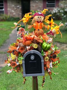 a mailbox decorated with fall decorations in front of a house