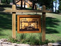 a welcome to broken oak sign in front of a log cabin on the side of a hill