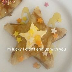 two pieces of food on a white plate with words written in the middle and stars painted on them